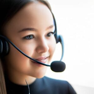 A girl wearing a headset and smiling.